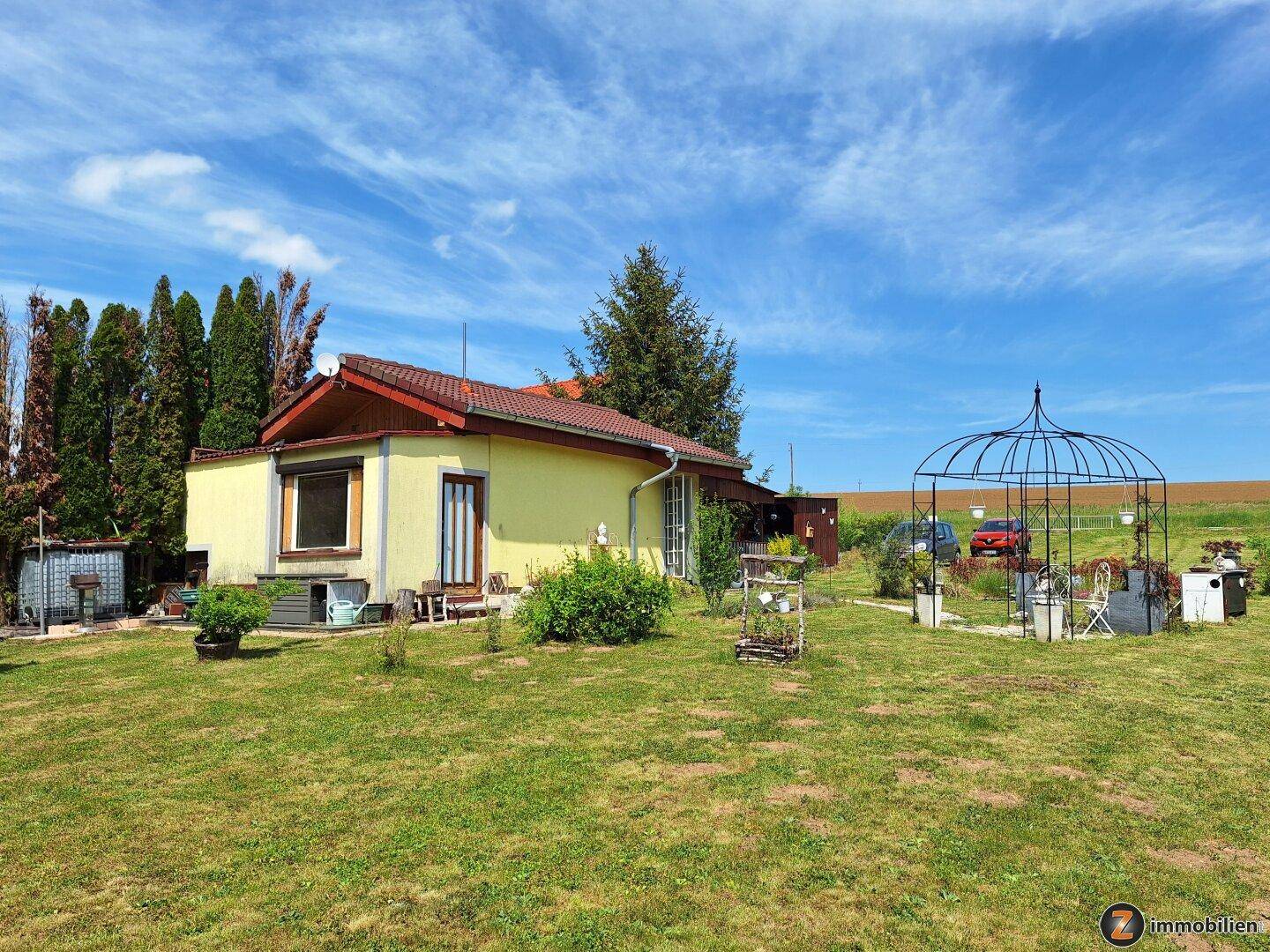 Gesamtansicht des Hauses mit großem Garten, Pavillon und weitem Blick in die Landschaft.