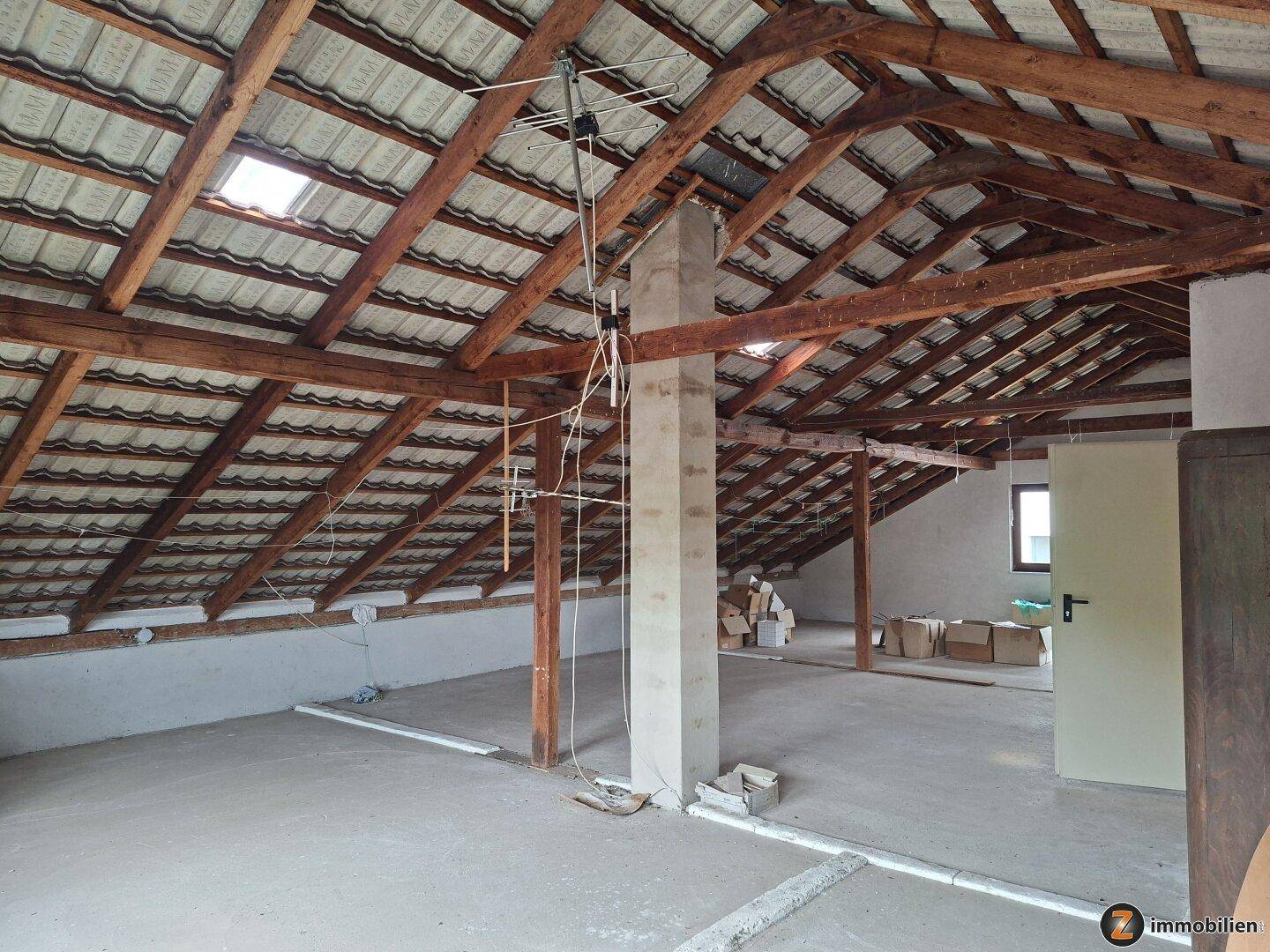 Geräumiger Dachboden mit Holzbalken, Dachfenstern und viel Potenzial für den Ausbau.