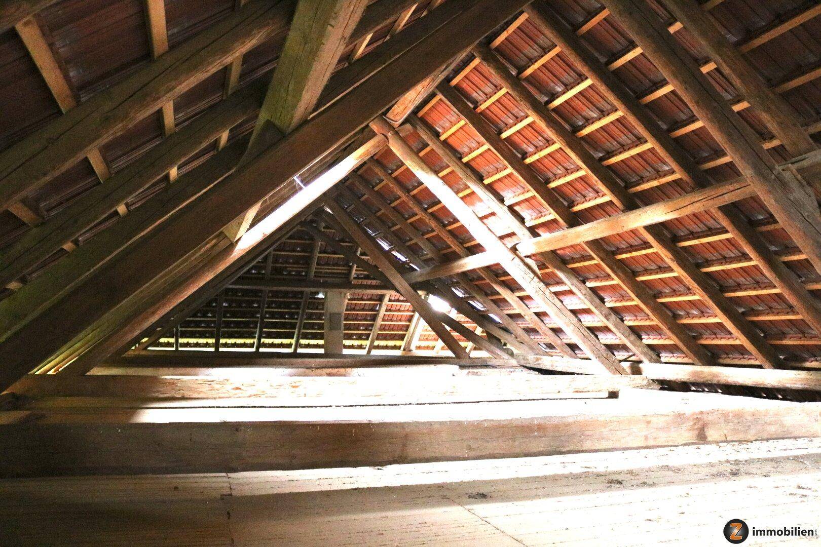 Dachboden mit sichtbaren Holzbalken und Ziegeln, bietet Ausbaupotenzial.