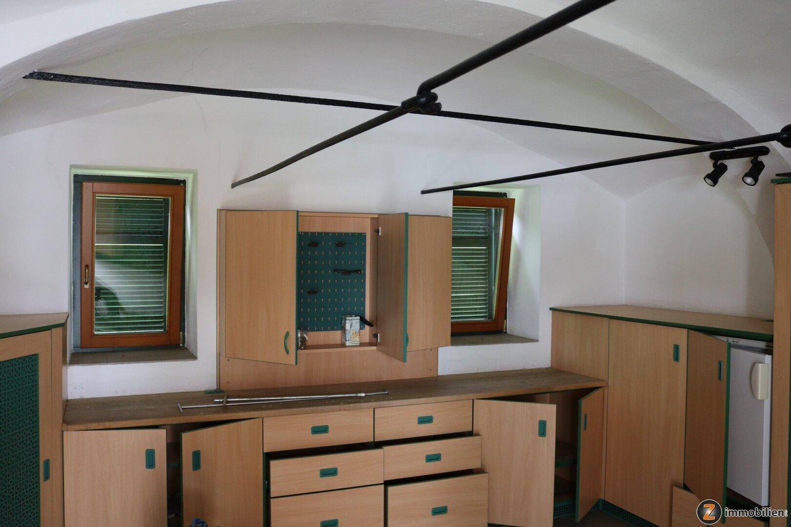 Werkstatt oder Abstellraum mit gewölbter Decke und praktischen Holzschränken.