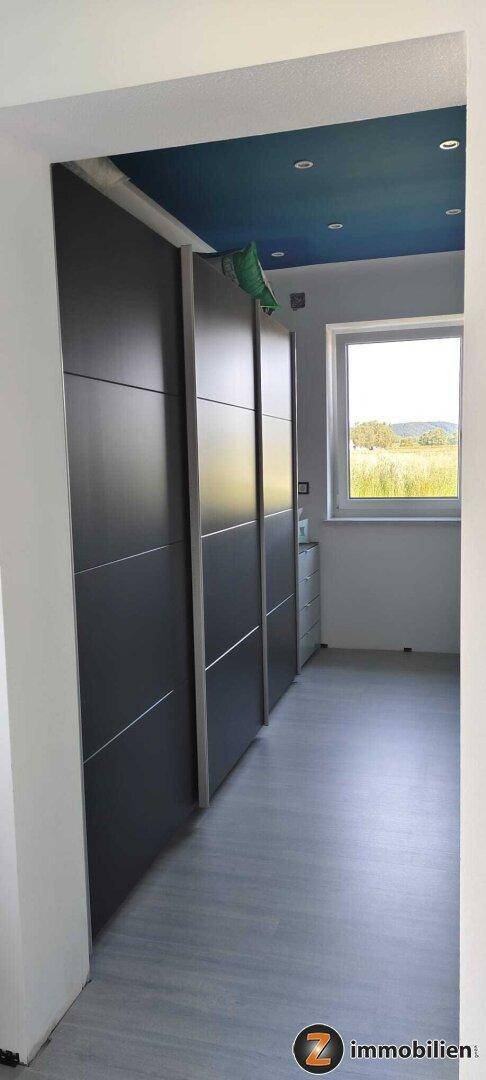 Flur mit Einbauschränken, Fenster und Blick auf die umliegende Landschaft.