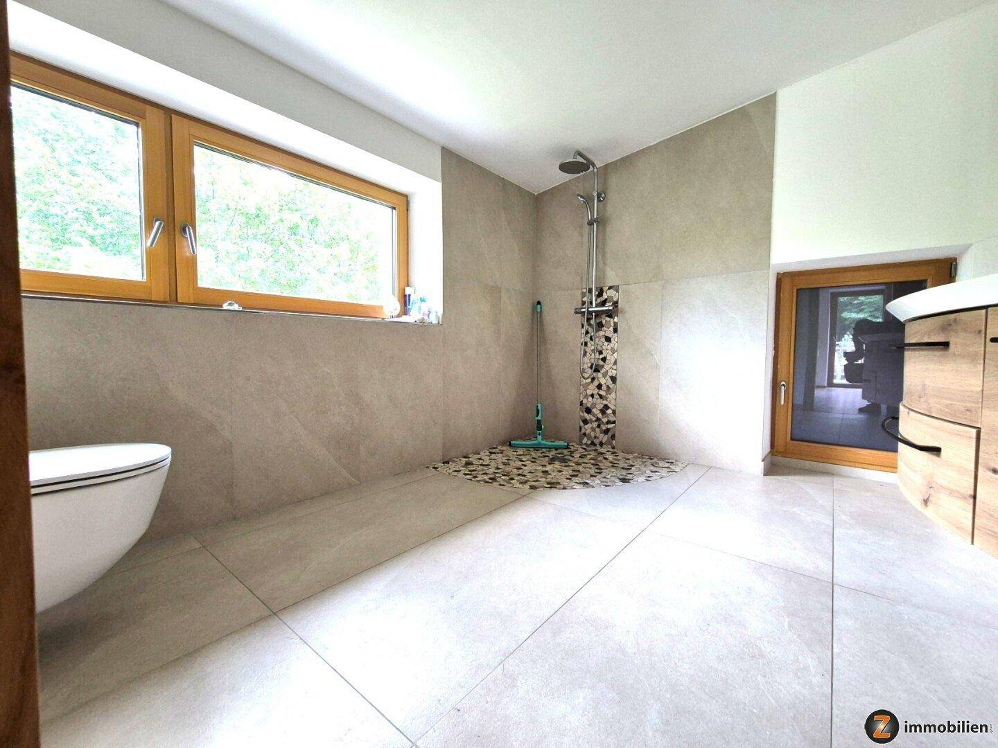 Geräumige begehbare Dusche mit Regenduschkopf und Fenster für natürliches Licht.