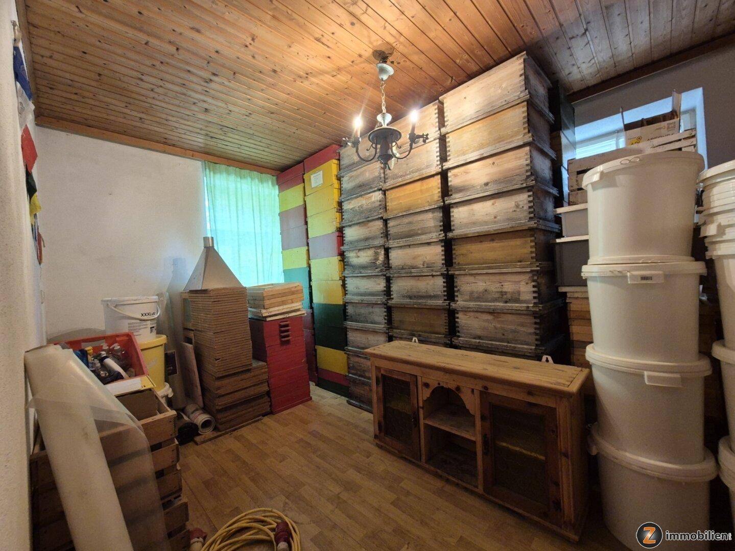 Lagerraum mit Holzdecke, gefüllten Kisten und Eimern, ideal für Vorräte oder Hobby.