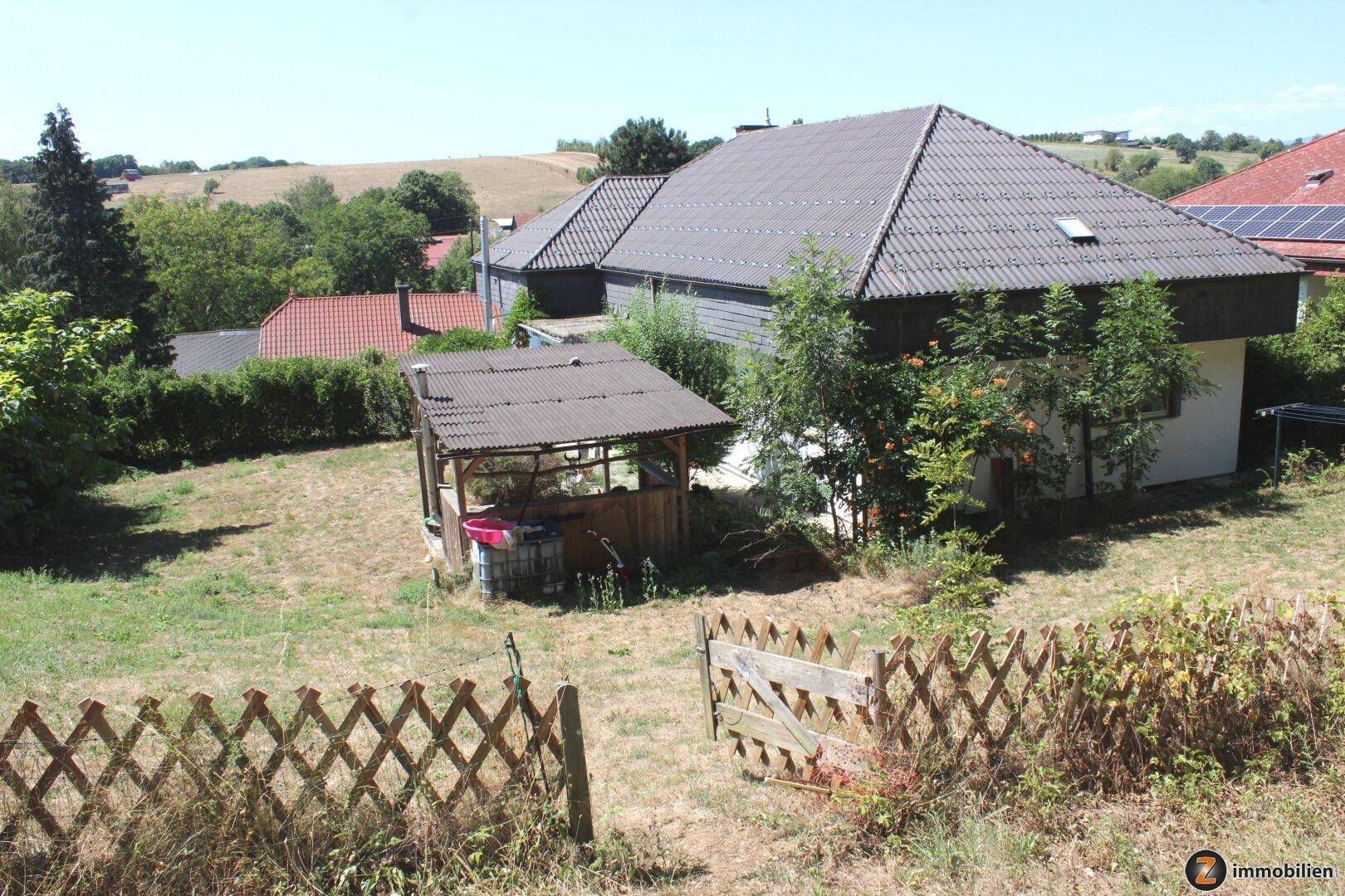 Weitläufiger Gartenbereich mit ländlichem Ausblick und einem kleinen Holzunterstand.