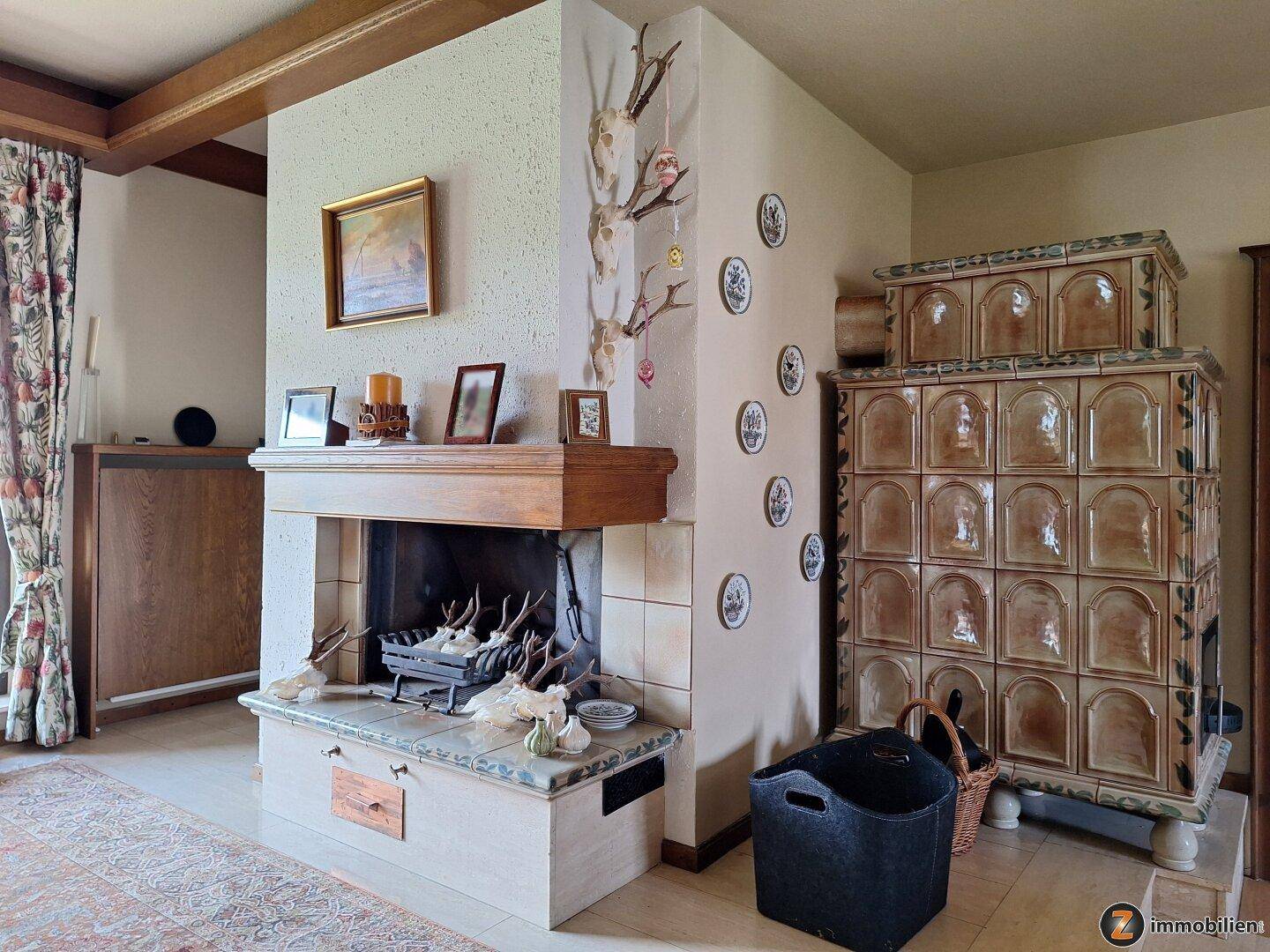 Wohnzimmer mit Kamin, traditionellem Kachelofen und rustikalen Dekorationen.