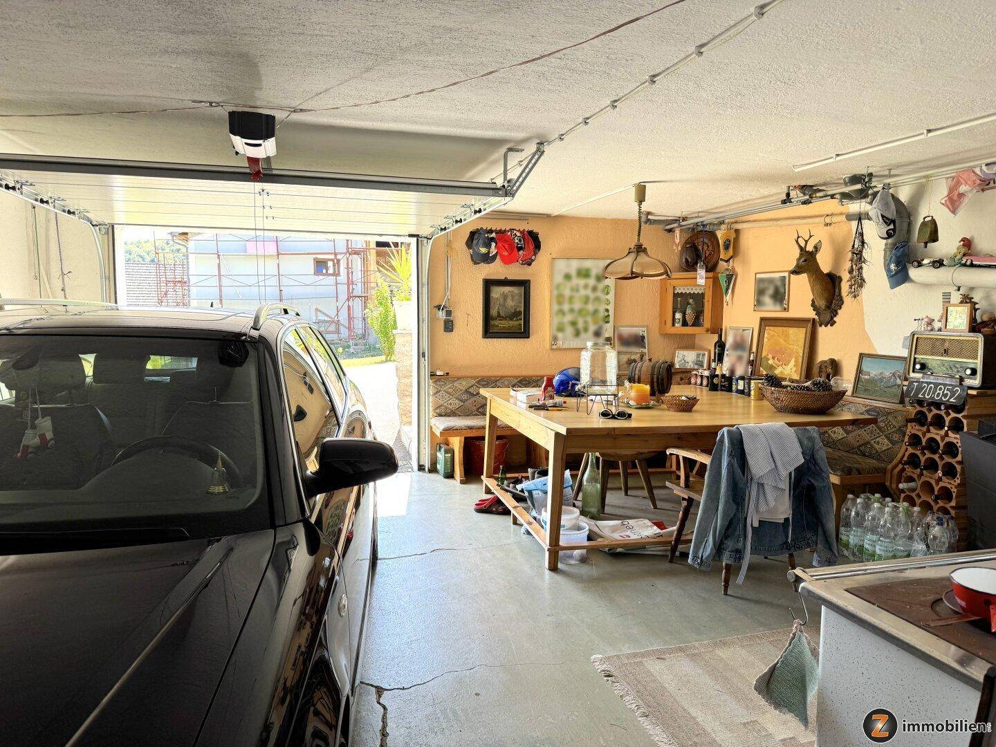 Geräumige Garage mit Platz für ein Fahrzeug und zusätzlichem Essbereich, dekoriert mit Jagdtrophäen.