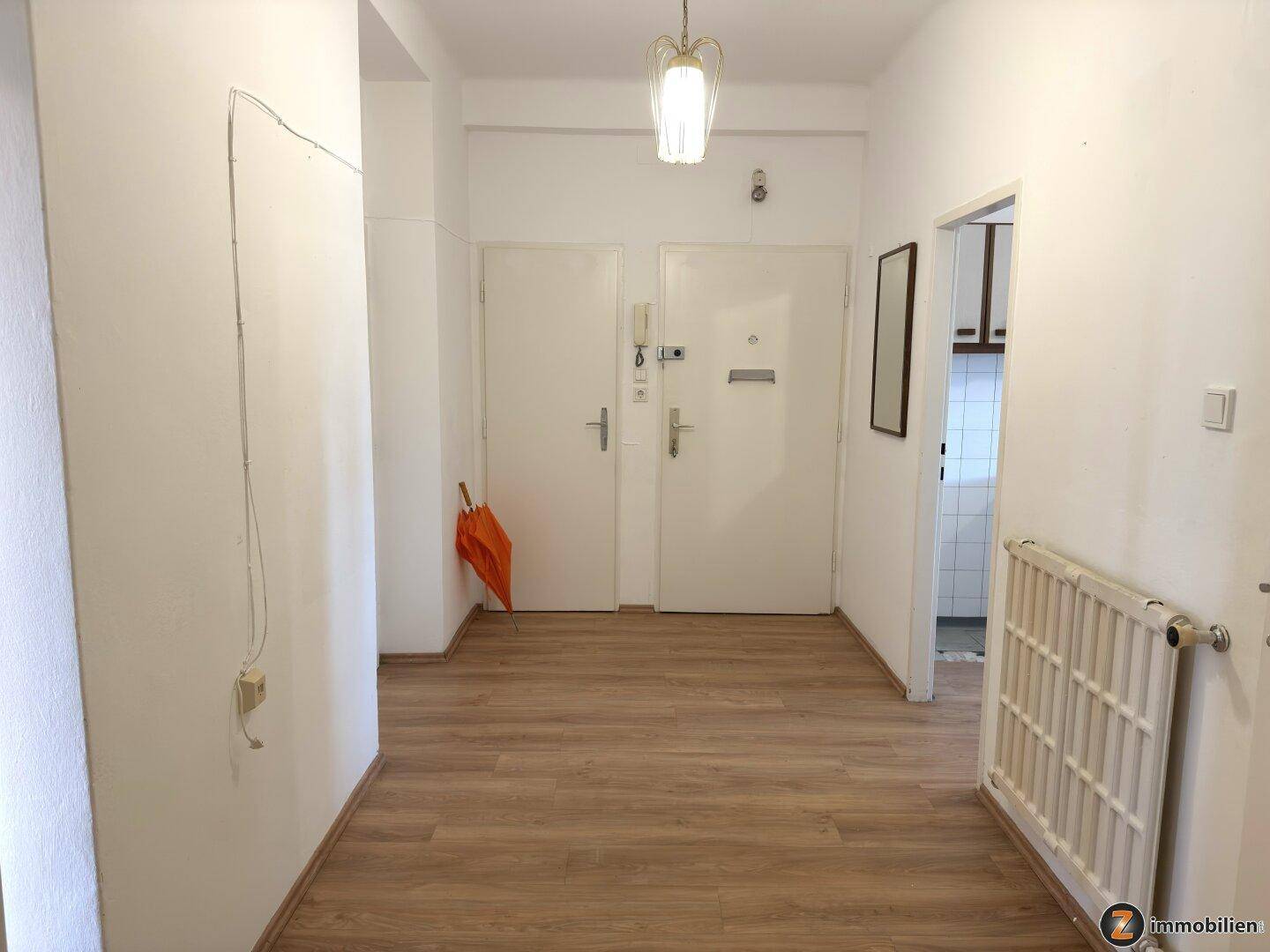 Heller Flur mit Laminatboden und Zugang zu verschiedenen Räumen der Wohnung.