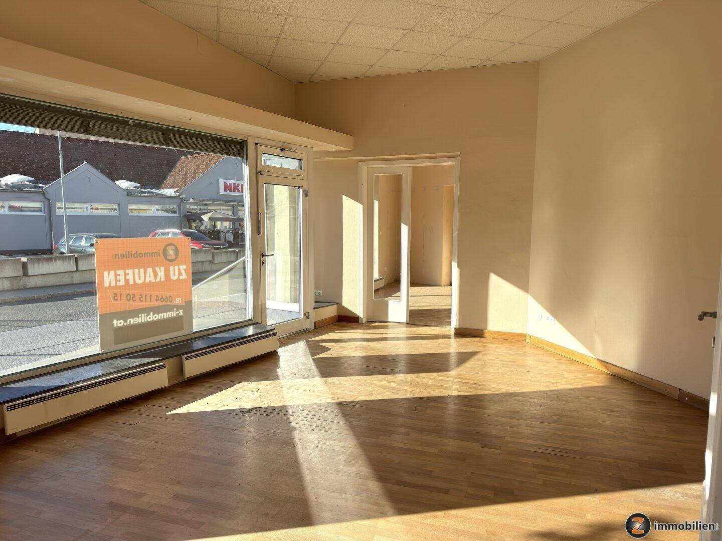 Heller Raum mit großen Fenstern, Parkettboden und viel Tageslicht, ideal für Wohn- oder Arbeitszwecke.