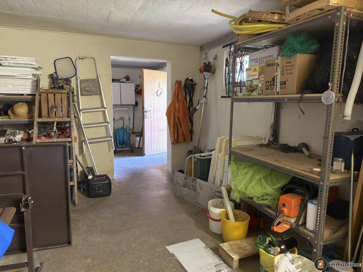 Geräumiger Abstellraum im Keller mit Regalen und verschiedenen Werkzeugen.