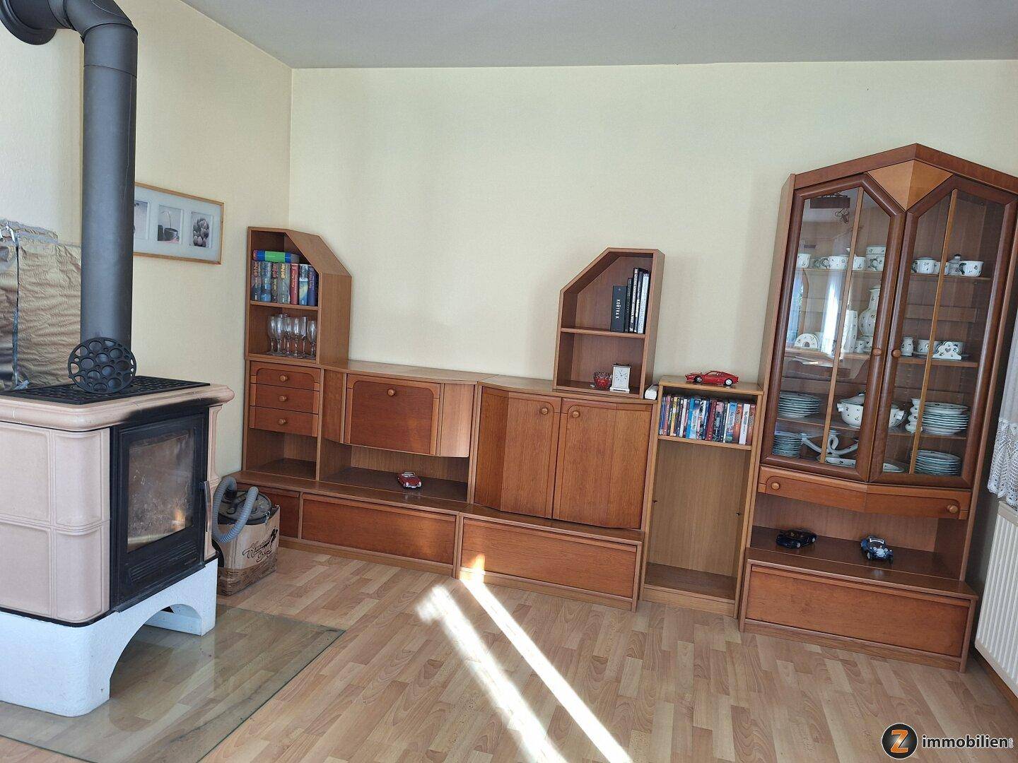 Wohnzimmer mit Kaminofen und traditionellen Holzmöbeln, bietet Stauraum.