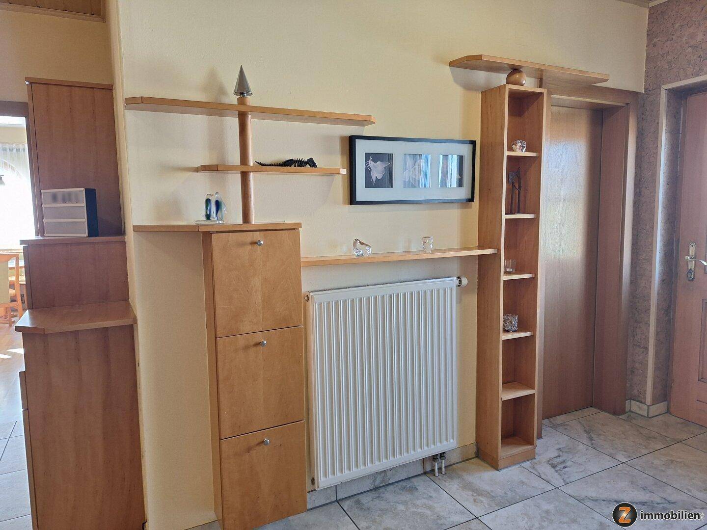 Flur mit Heizkörper und Holzregalen, bietet praktischen Stauraum.