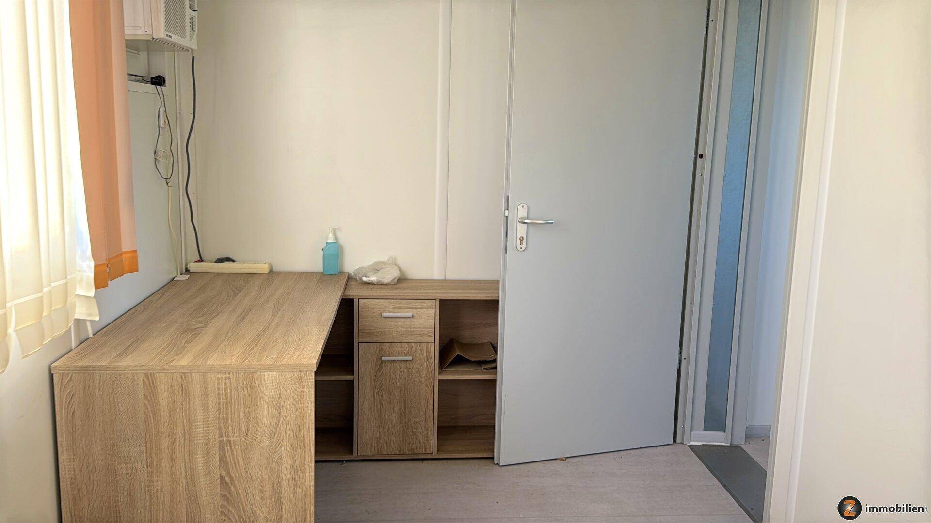 Funktionaler Raum mit Schreibtisch, Tür und Fenster, geeignet als Arbeitszimmer.