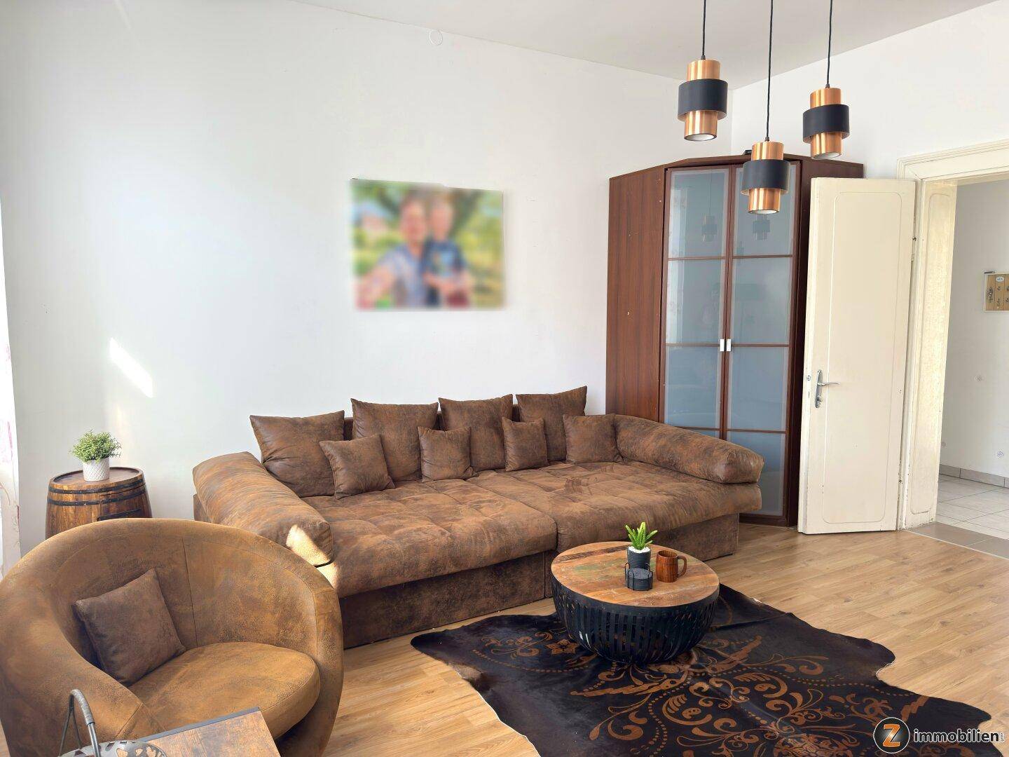 Heller Wohnbereich mit großem Sofa, stilvoller Dekoration und Laminatboden.