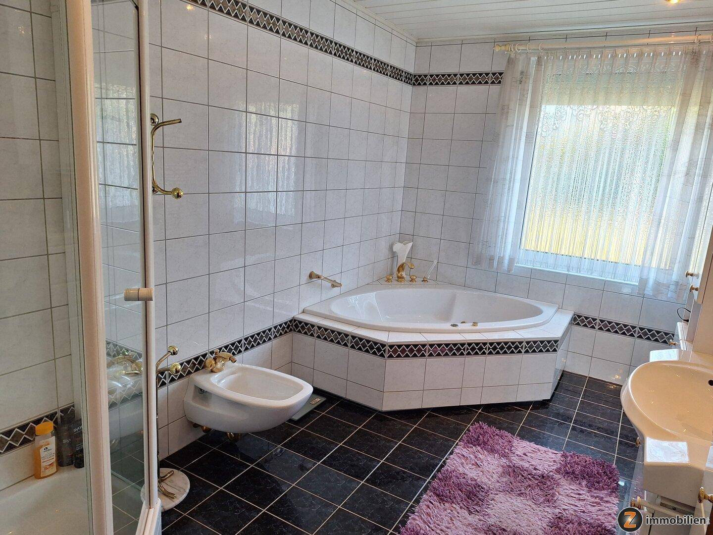 Geräumiges Badezimmer mit Eckbadewanne, Bidet, Duschkabine und Fenster.