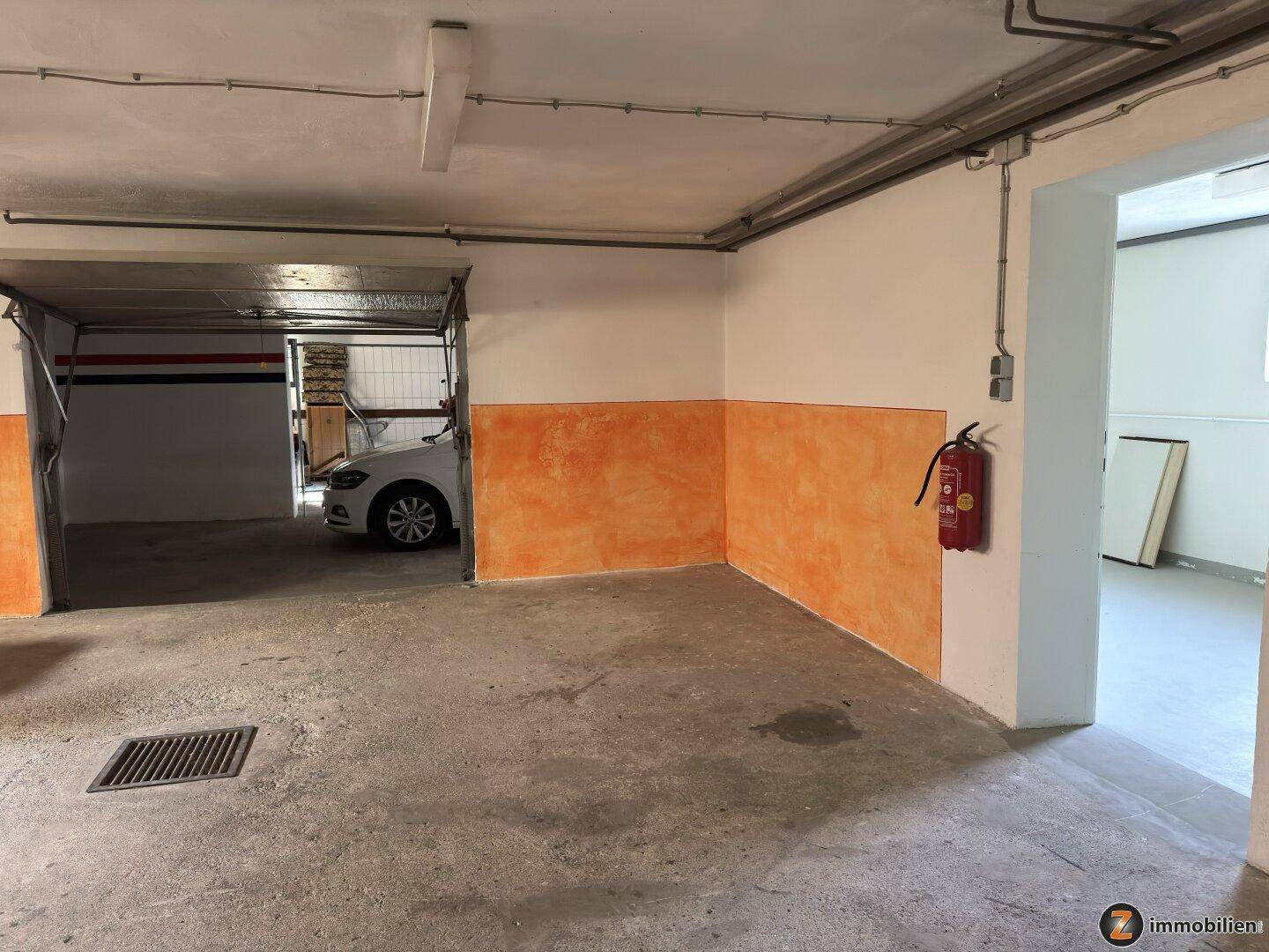 Geräumige Garage mit Betonboden und Platz für mehrere Fahrzeuge.