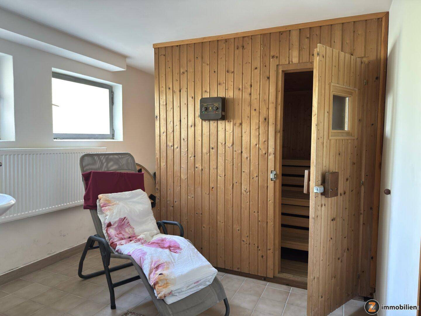 Wellnessbereich mit Sauna, Liege und Holzverkleidung für pure Entspannung.