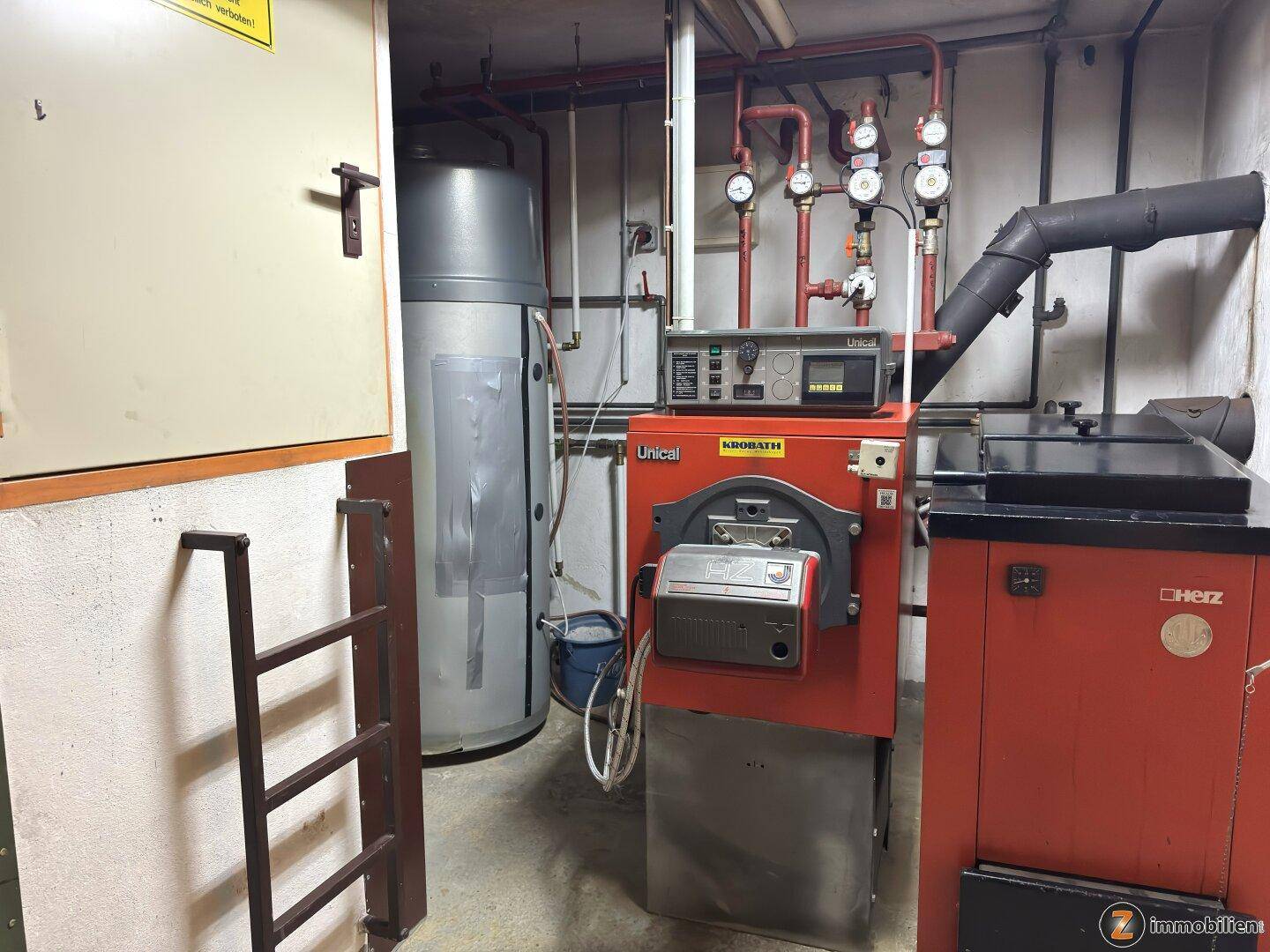 Heizungsraum mit moderner Heizungsanlage und Warmwasserspeicher.