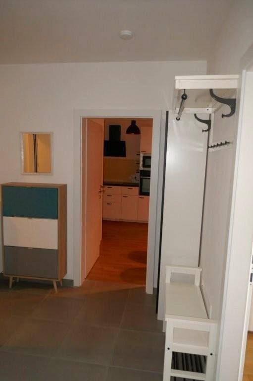 Eingangsbereich mit Garderobe und Blick in die angrenzende Küche.