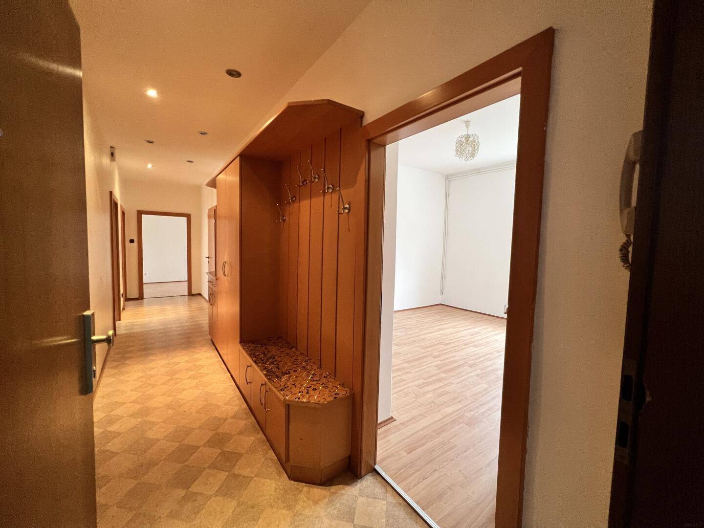 Langer Flur mit integrierter Garderobe und Zugang zu weiteren Zimmern, ausgestattet mit praktischem Linoleumboden.