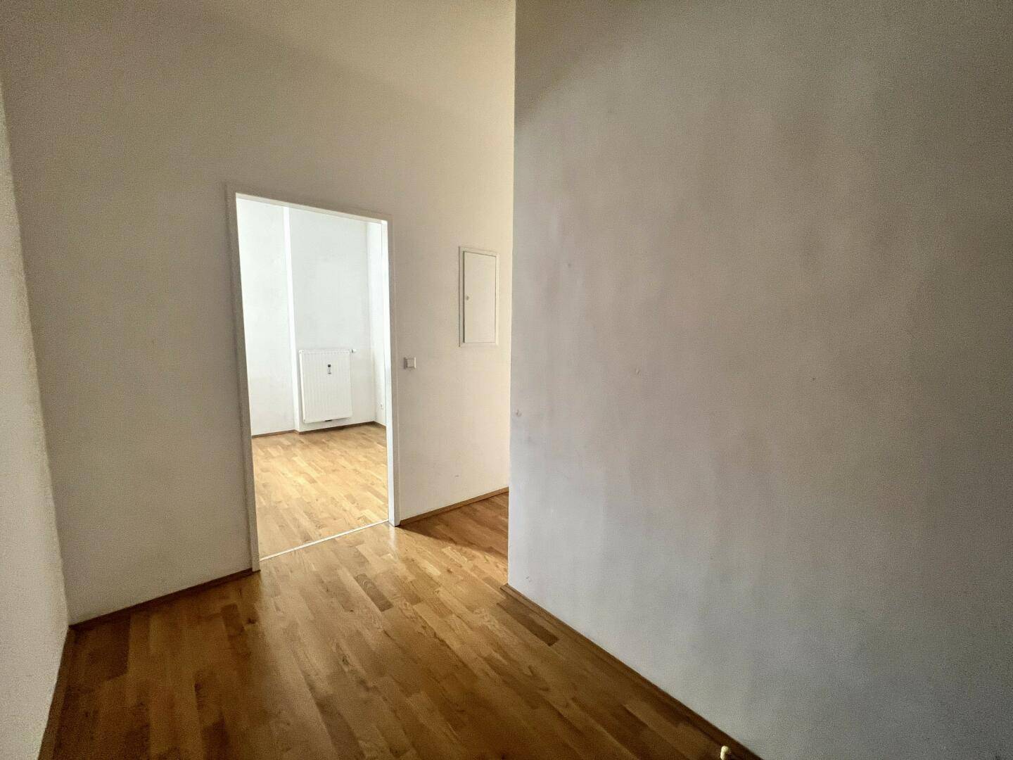 Langer Flur mit Parkettboden und Zugang zu verschiedenen Räumen, verbindet die Wohnbereiche.