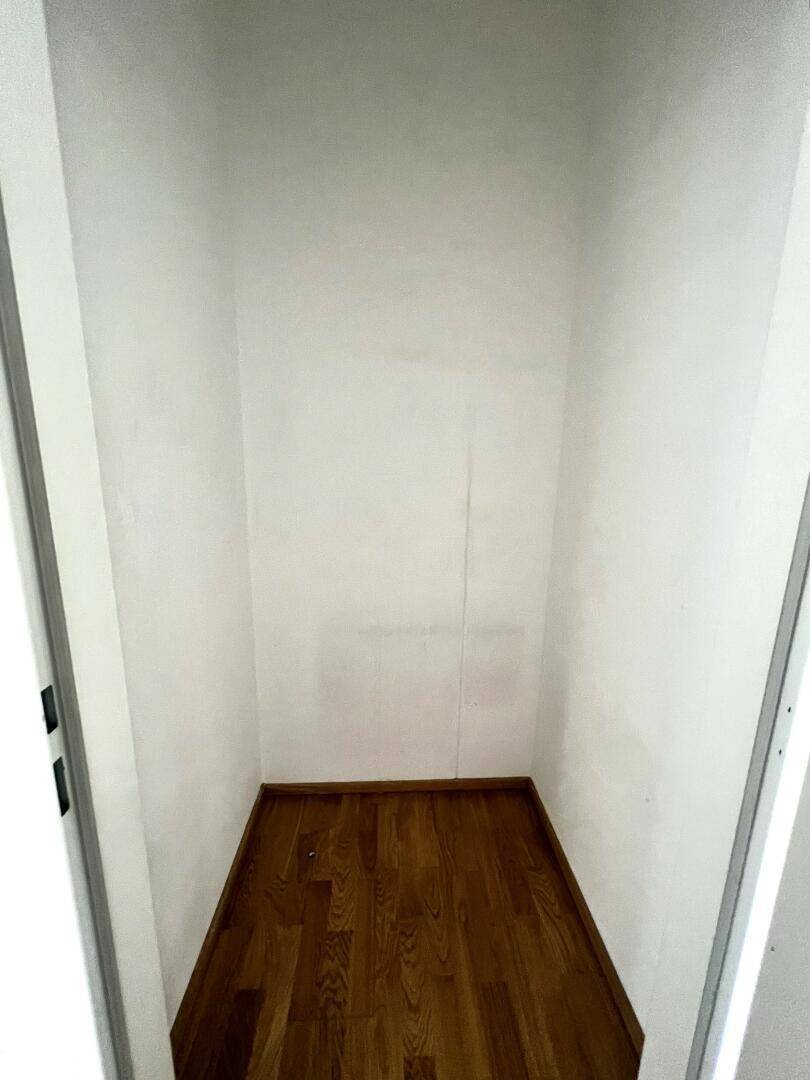 Kleiner Abstellraum mit Parkettboden und weißen Wänden, ideal für zusätzlichen Stauraum.