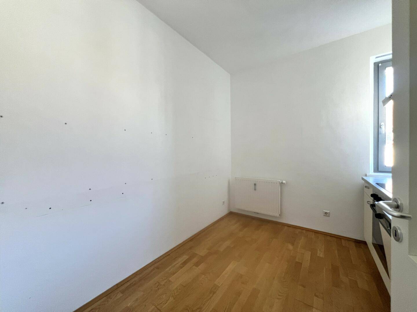 Kleiner, heller Raum mit Parkettboden und Fenster, vielseitig nutzbar und gut gepflegt.