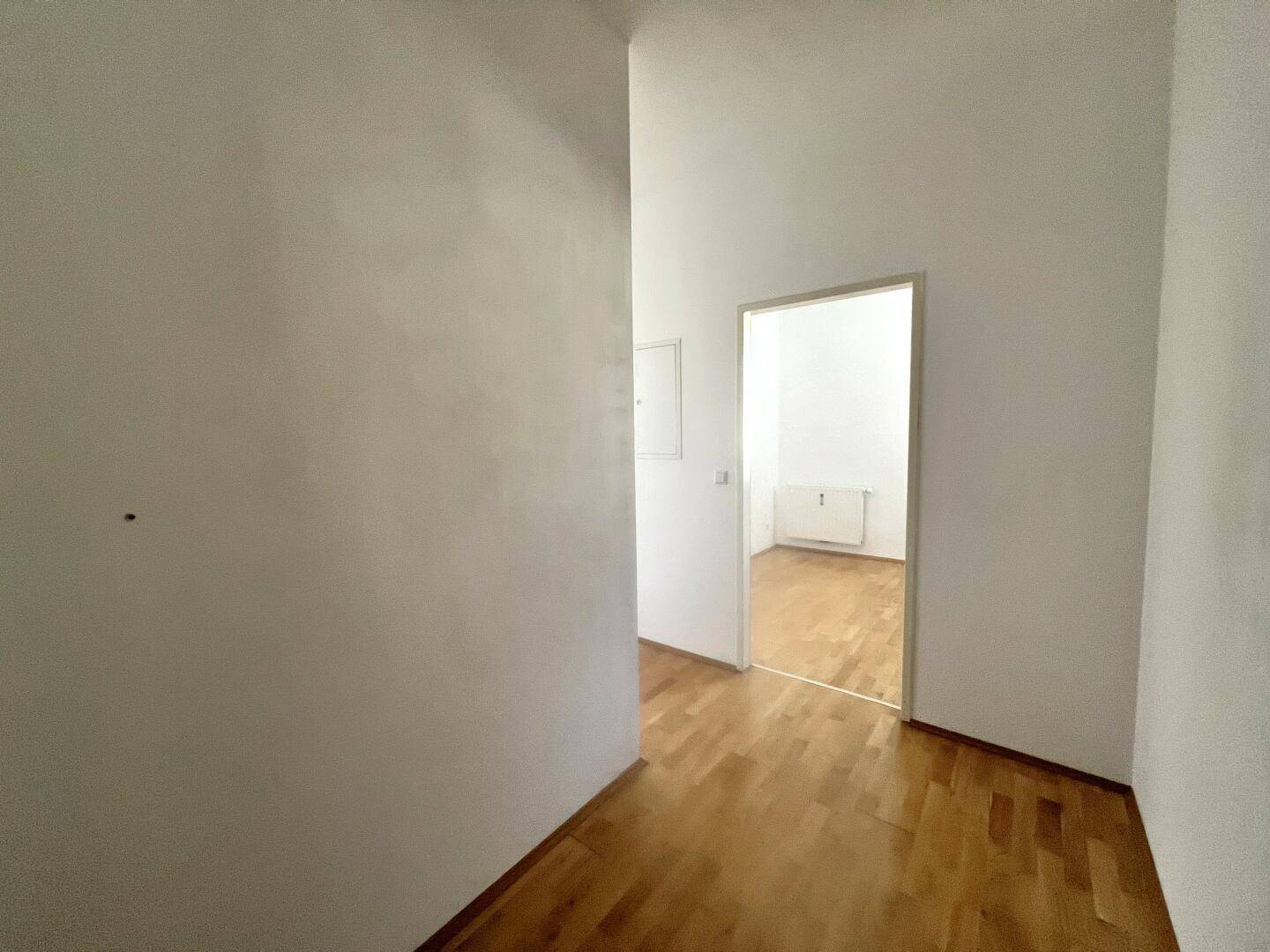 Leerer Flur mit Parkettboden und Zugang zu weiteren Räumen, in gutem Zustand.