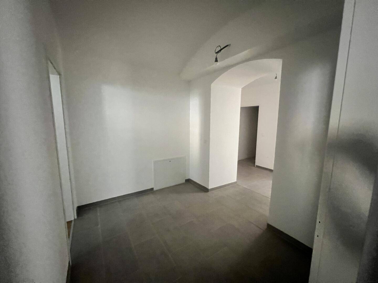 Flur mit dunklen Fliesen und gewölbter Decke, verbindet verschiedene Wohnbereiche.