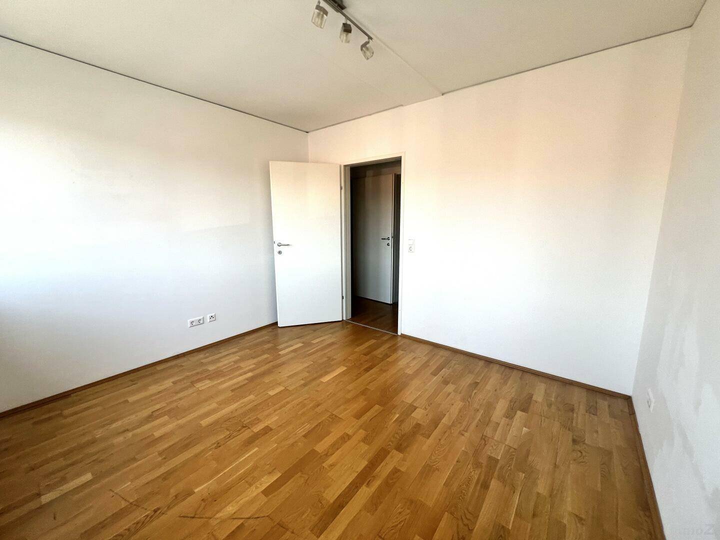 Geräumiges Schlafzimmer mit Parkettboden und weiß gestrichenen Wänden, bereit zur individuellen Gestaltung.