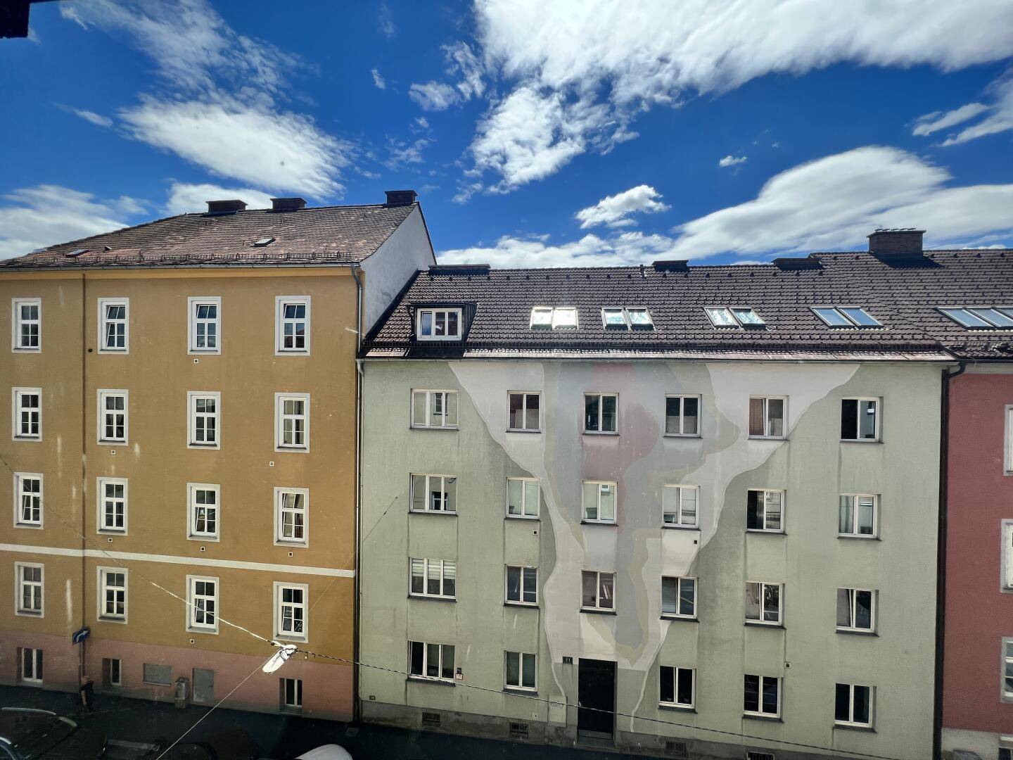 Fassadenansicht von zwei mehrstöckigen Wohngebäuden unter blauem Himmel.
