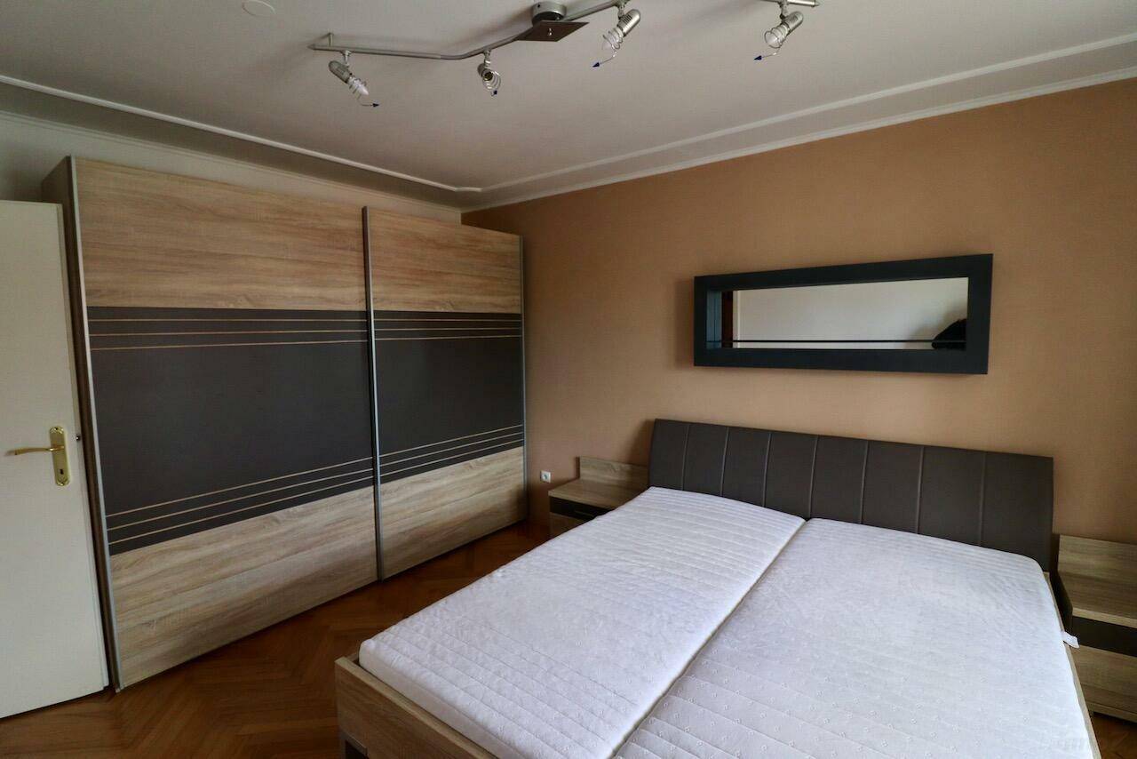 Schlafzimmer mit Doppelbett, Nachttischen und großem Kleiderschrank mit Schiebetüren.