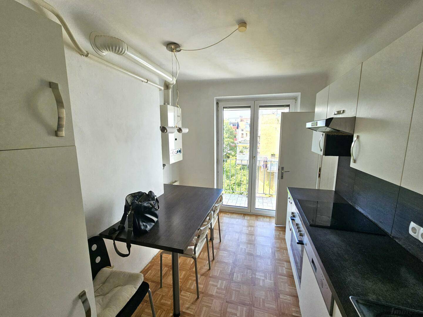 Küche mit Essbereich, Einbauküche und Zugang zu einem kleinen Balkon.