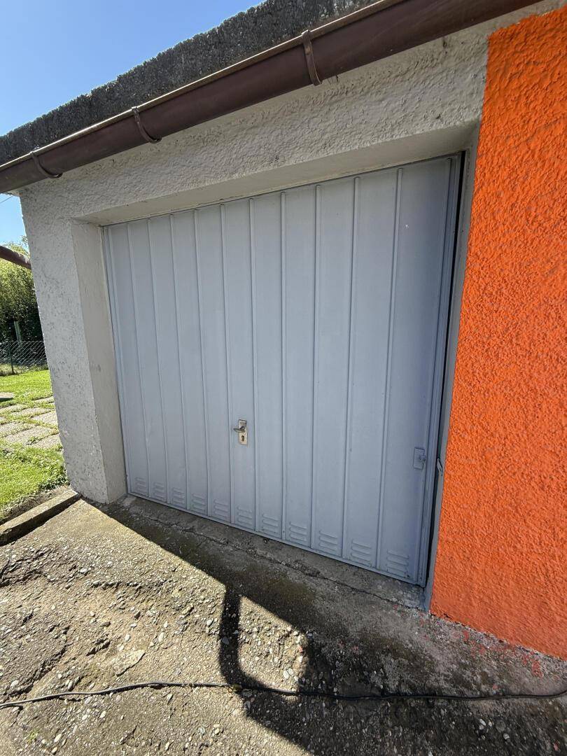 Einzelgarage mit Schwingtor und direktem Zugang zum Grundstück.