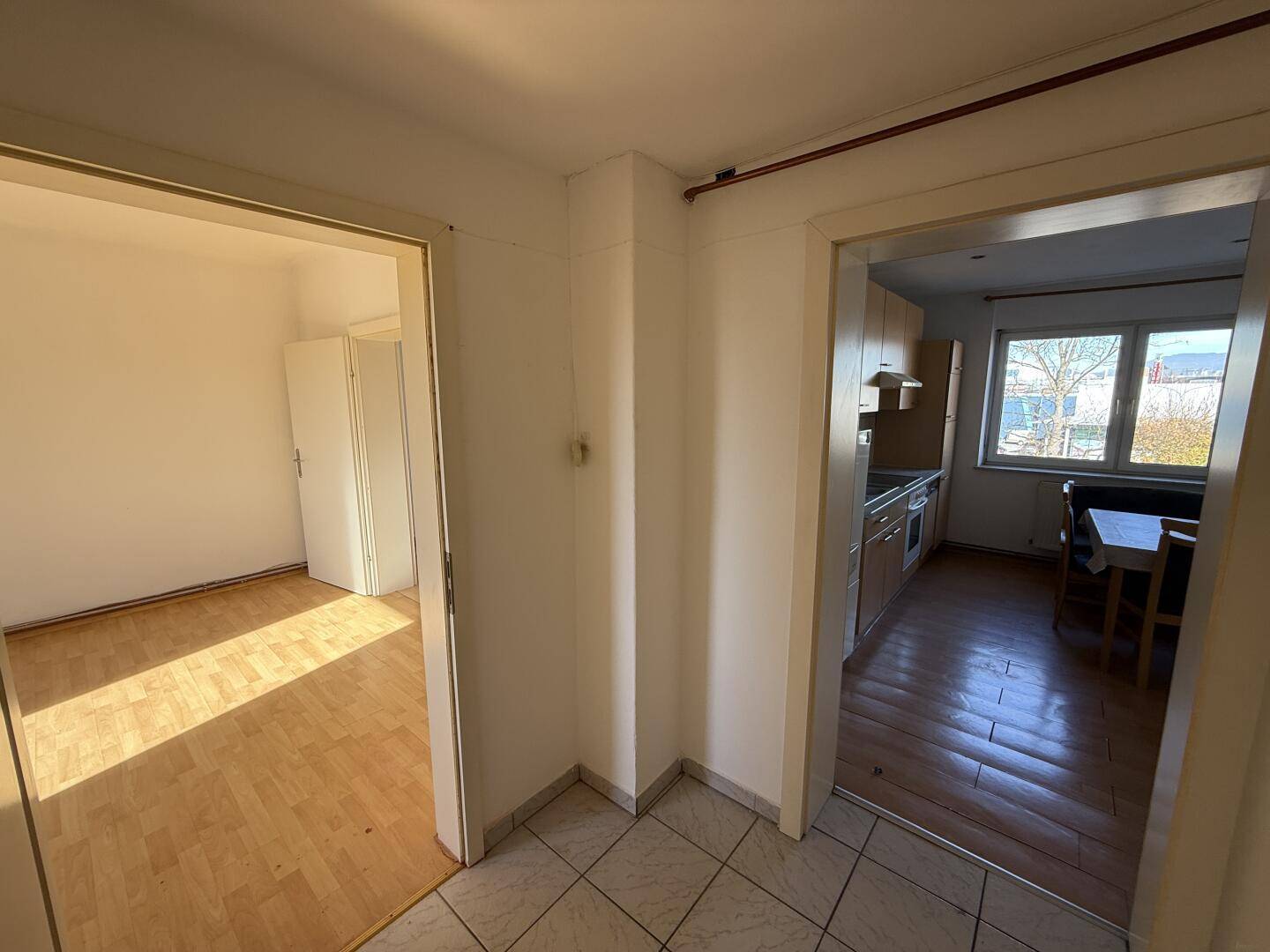 Heller Flurbereich mit Fliesenboden und Zugang zu weiteren Zimmern der Wohnung.