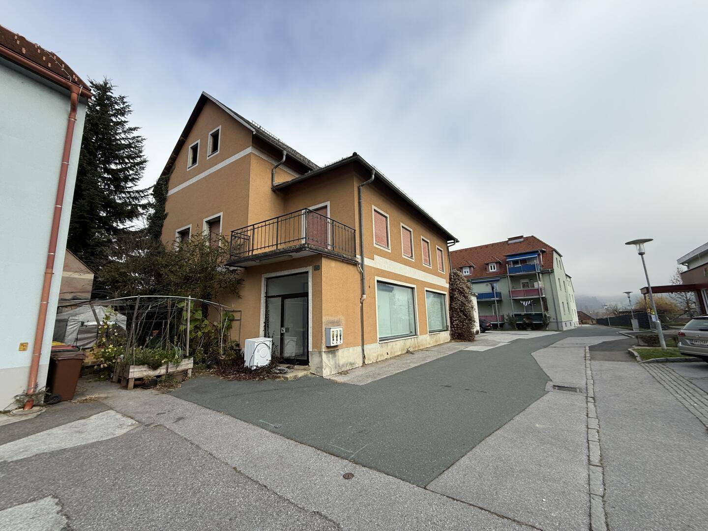 Weitwinkelansicht des Gebäudes von außen, mit Straße und umliegenden Häusern in der Nachbarschaft.