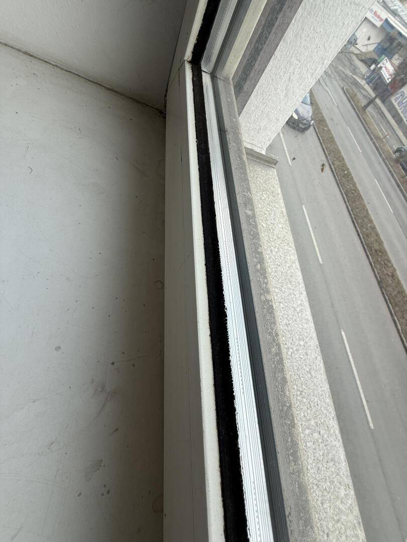 Nahaufnahme eines Fensters mit Blick auf eine belebte Straße.