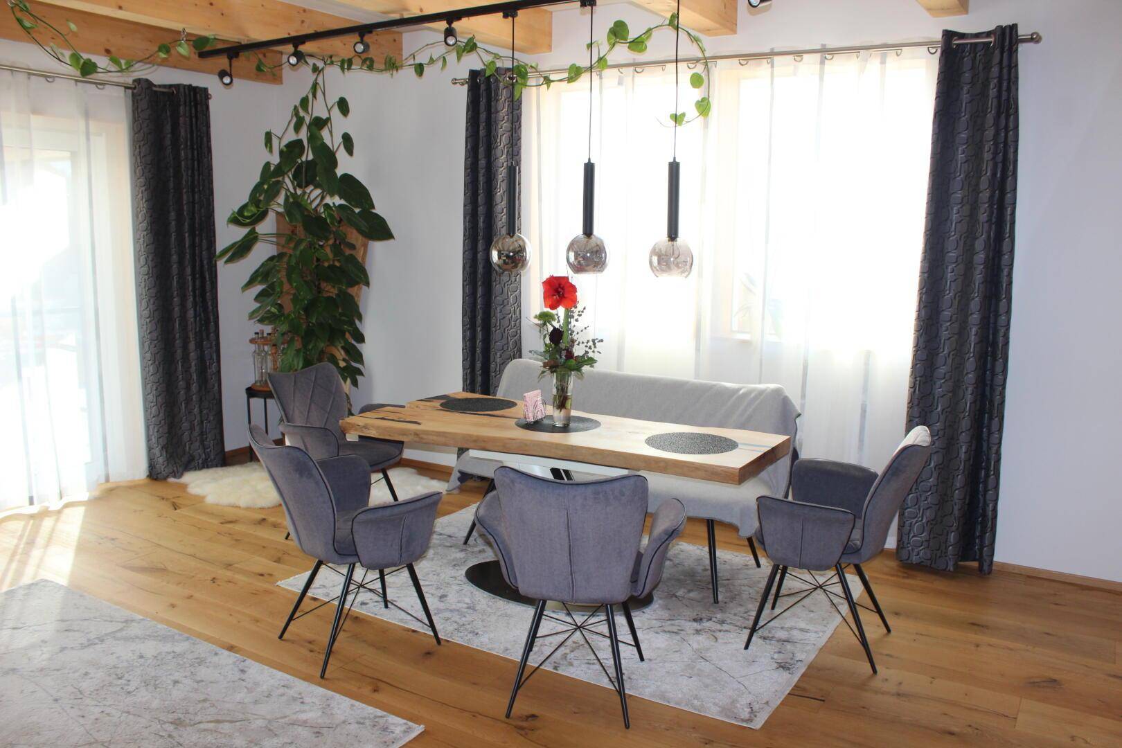 Heller Essbereich mit Holztisch, modernen Stühlen und großen Fenstern für viel Tageslicht.