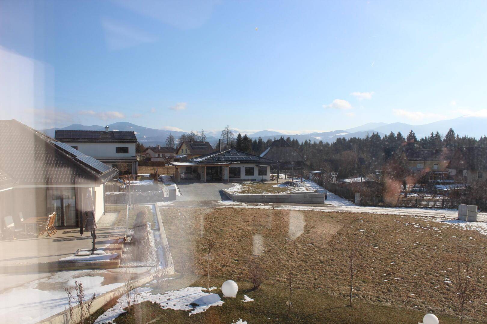 Panoramablick auf die umliegende Wohnsiedlung und die majestätische Bergkette in der Ferne.
