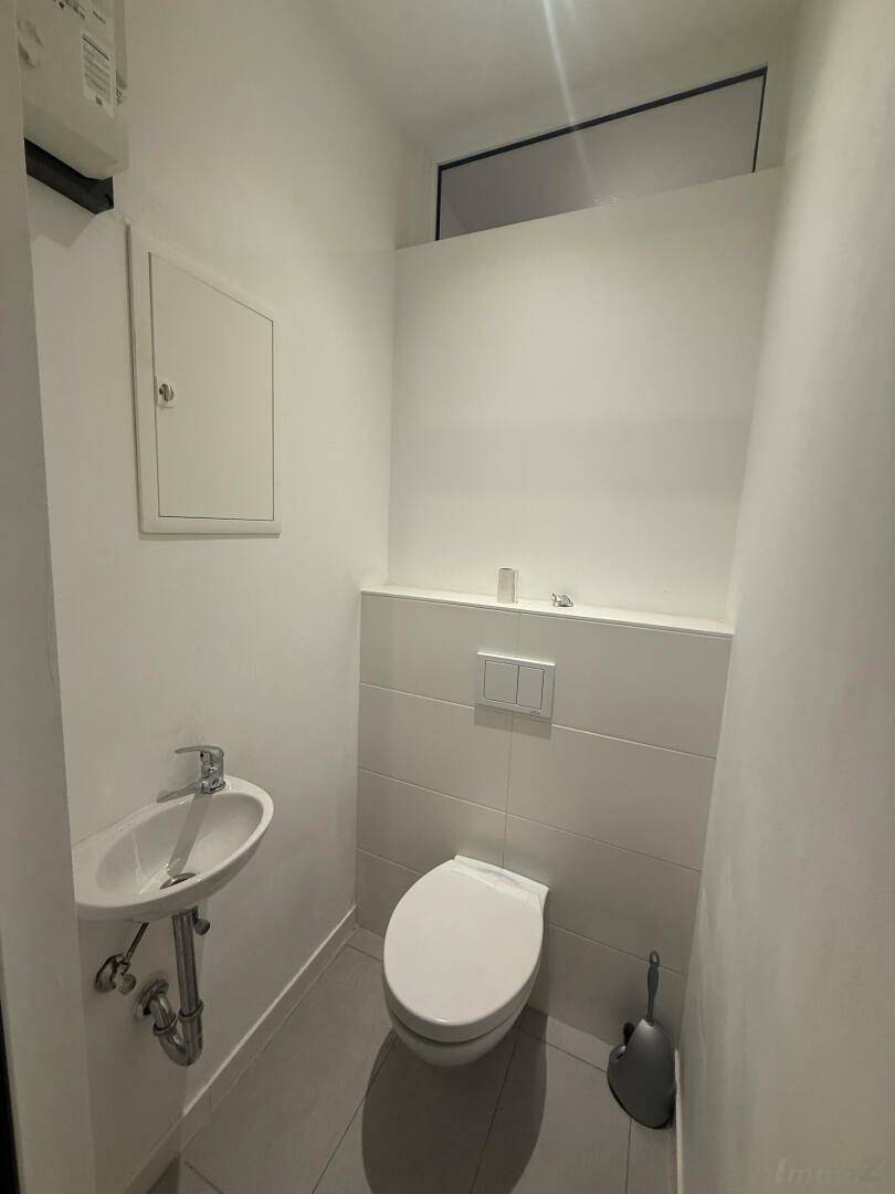 Modernes Gäste-WC mit wandhängender Toilette und kleinem Waschbecken, sauber und funktional.