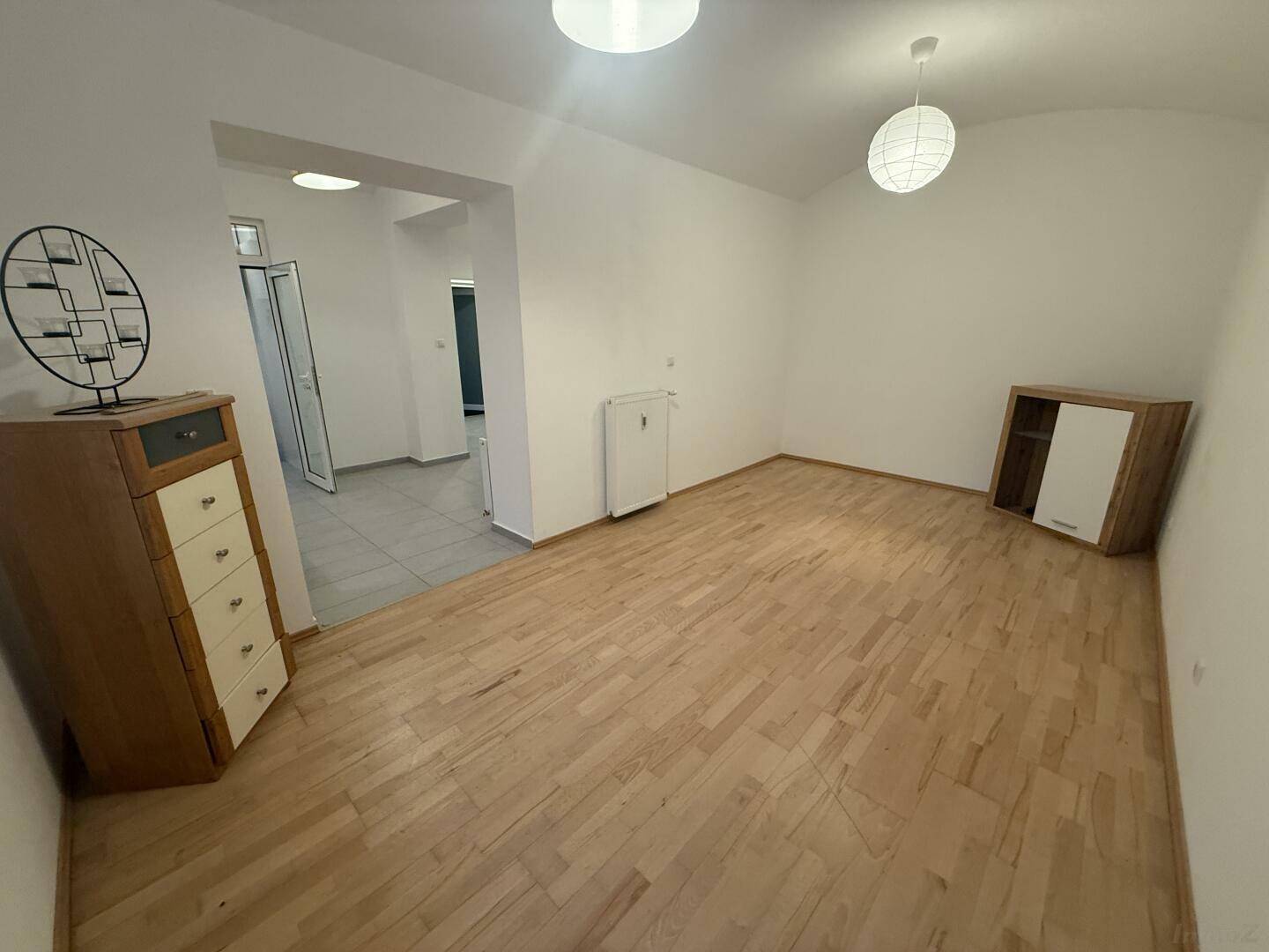Heller Wohnraum mit Parkettboden und Zugang zu weiteren Zimmern, offen und einladend.