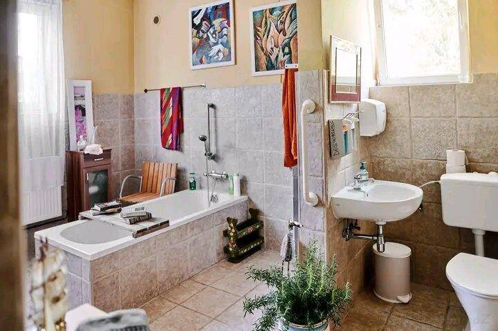 Badezimmer mit Badewanne, Fliesenboden und Wandfliesen in neutralen Farbtönen.