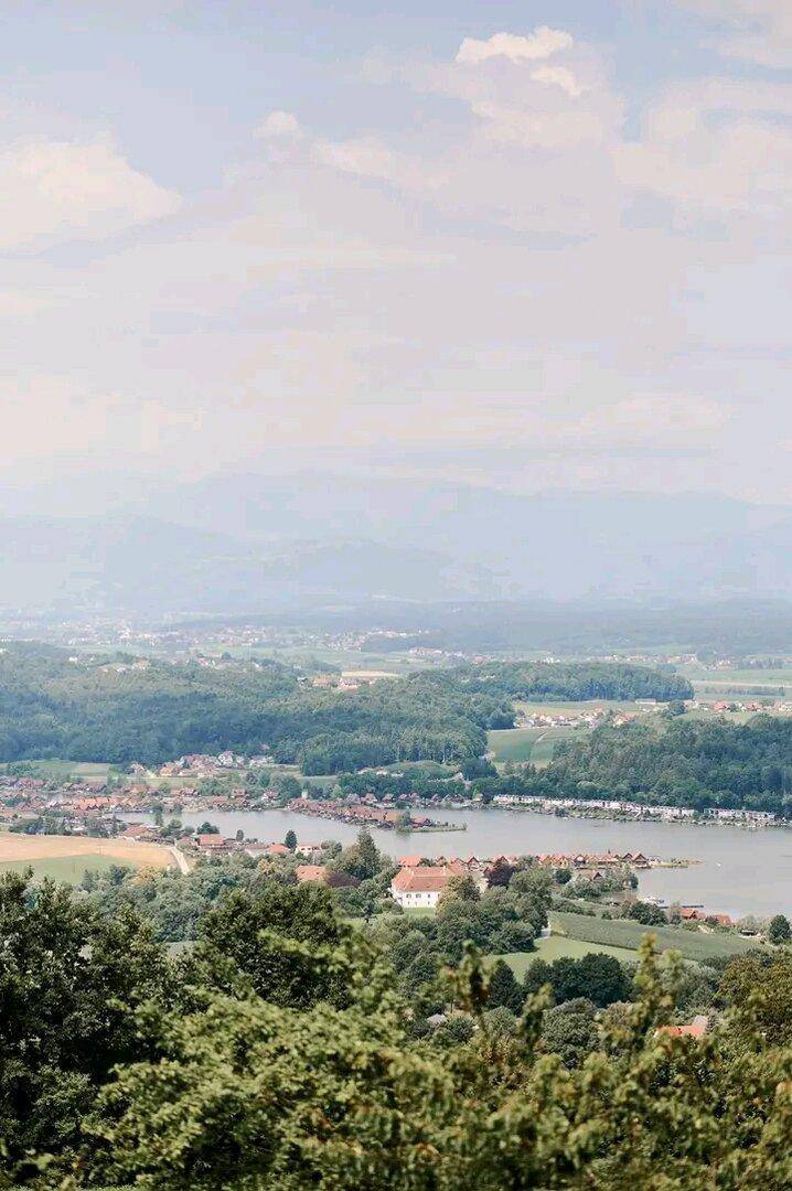 Malerischer Ausblick über eine Seenlandschaft mit umliegenden Wäldern und kleinen Ortschaften.