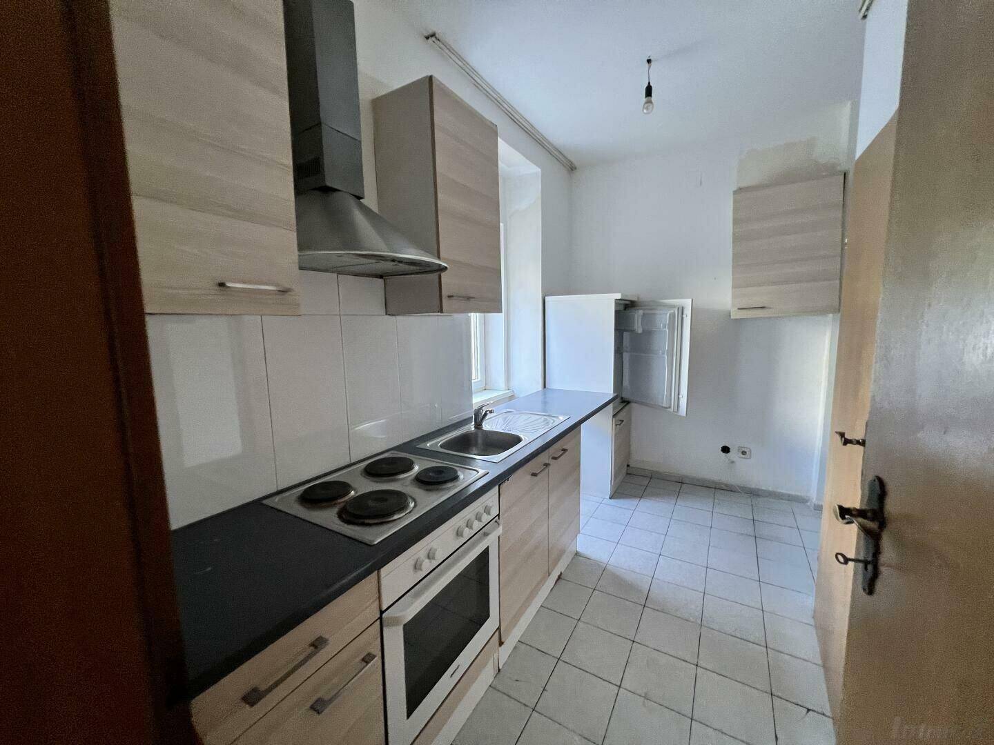 Kompakte Einbauküche mit Kochfeld, Backofen und Dunstabzugshaube, praktisch und gut erhalten.