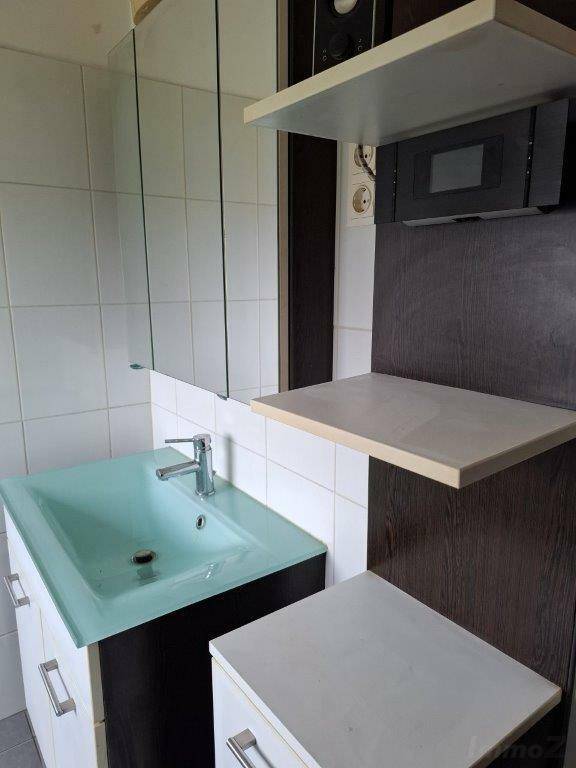 Badezimmer mit modernem Waschbecken, Spiegelschrank und weißen Fliesen.