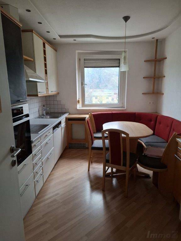 Gemütliche Wohnküche mit Essecke, Einbauküche und Fensterblick ins Grüne.