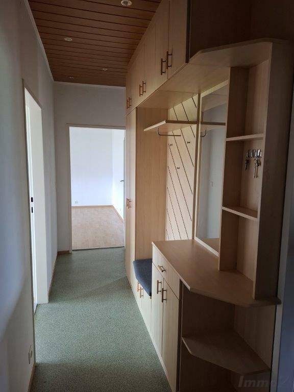 Heller Flur mit Holzdecke und Einbauschränken, der zu weiteren Räumen führt.