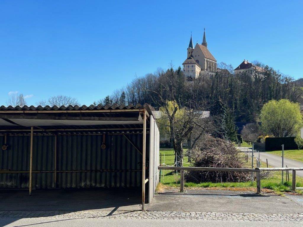 Offener Carport mit Blick auf eine historische Kirche auf einem Hügel.