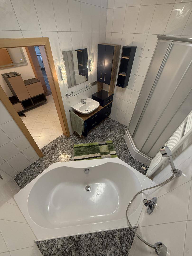 Geräumiges Badezimmer mit Eckbadewanne, Duschkabine und modernem Waschtisch.
