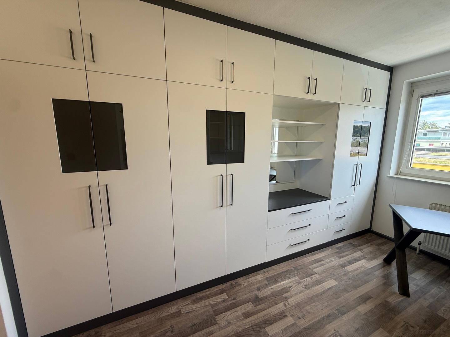 Maßgefertigte Einbauschränke mit viel Stauraum und integrierten Regalen im Arbeitszimmer.