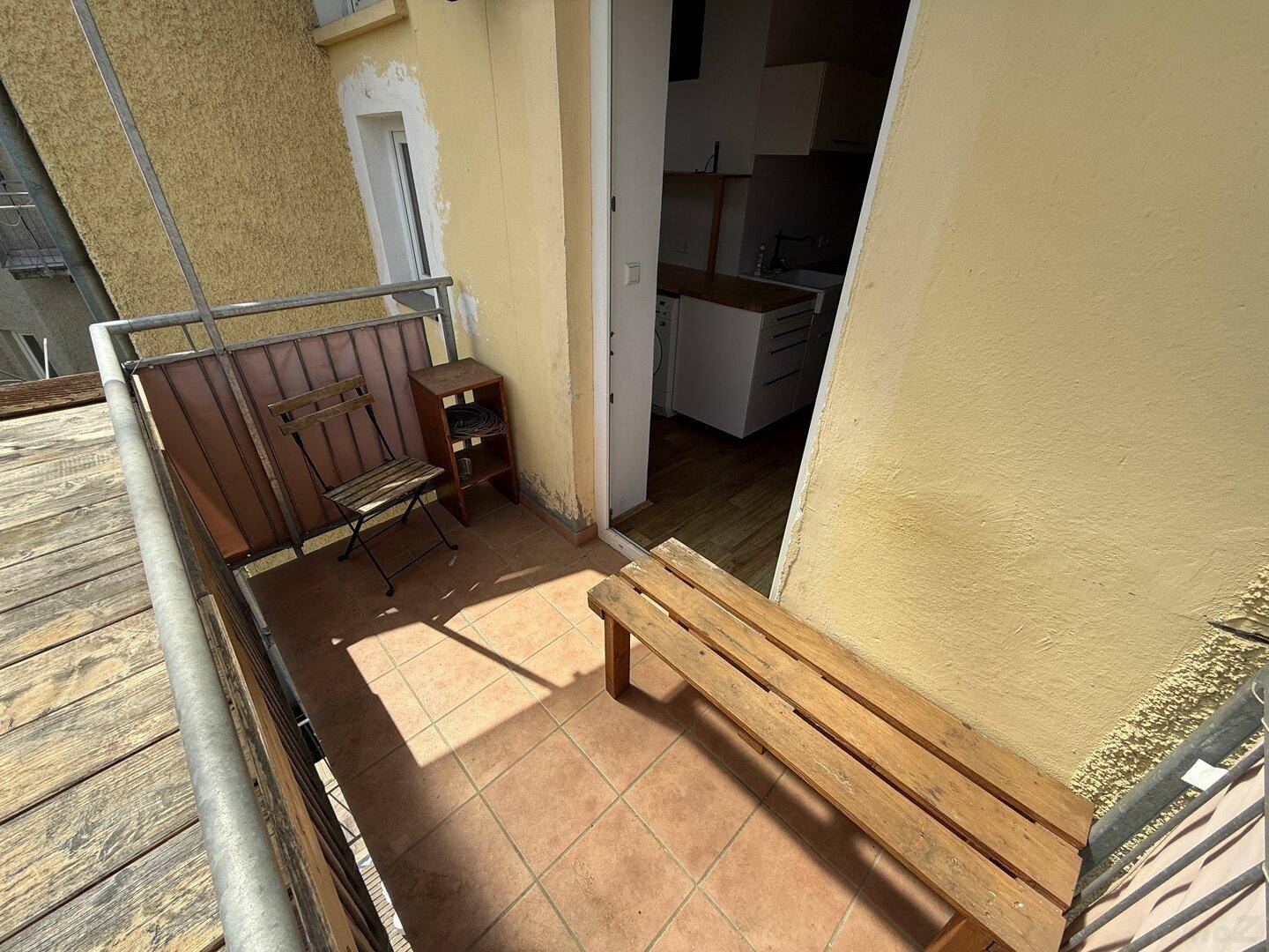 Gemütlicher Balkon mit Fliesenboden, Sitzgelegenheiten und direktem Zugang zur Küche.